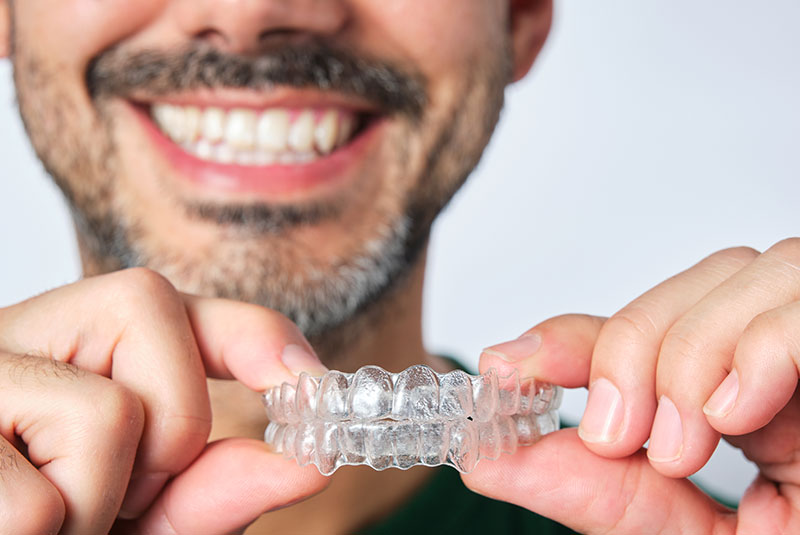 man holding clear aligners