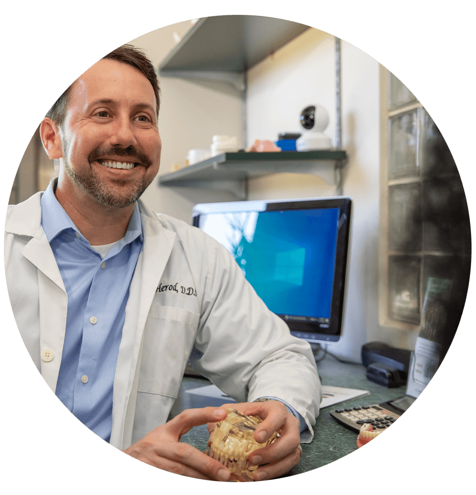 doctor holding a full arch model for Patient